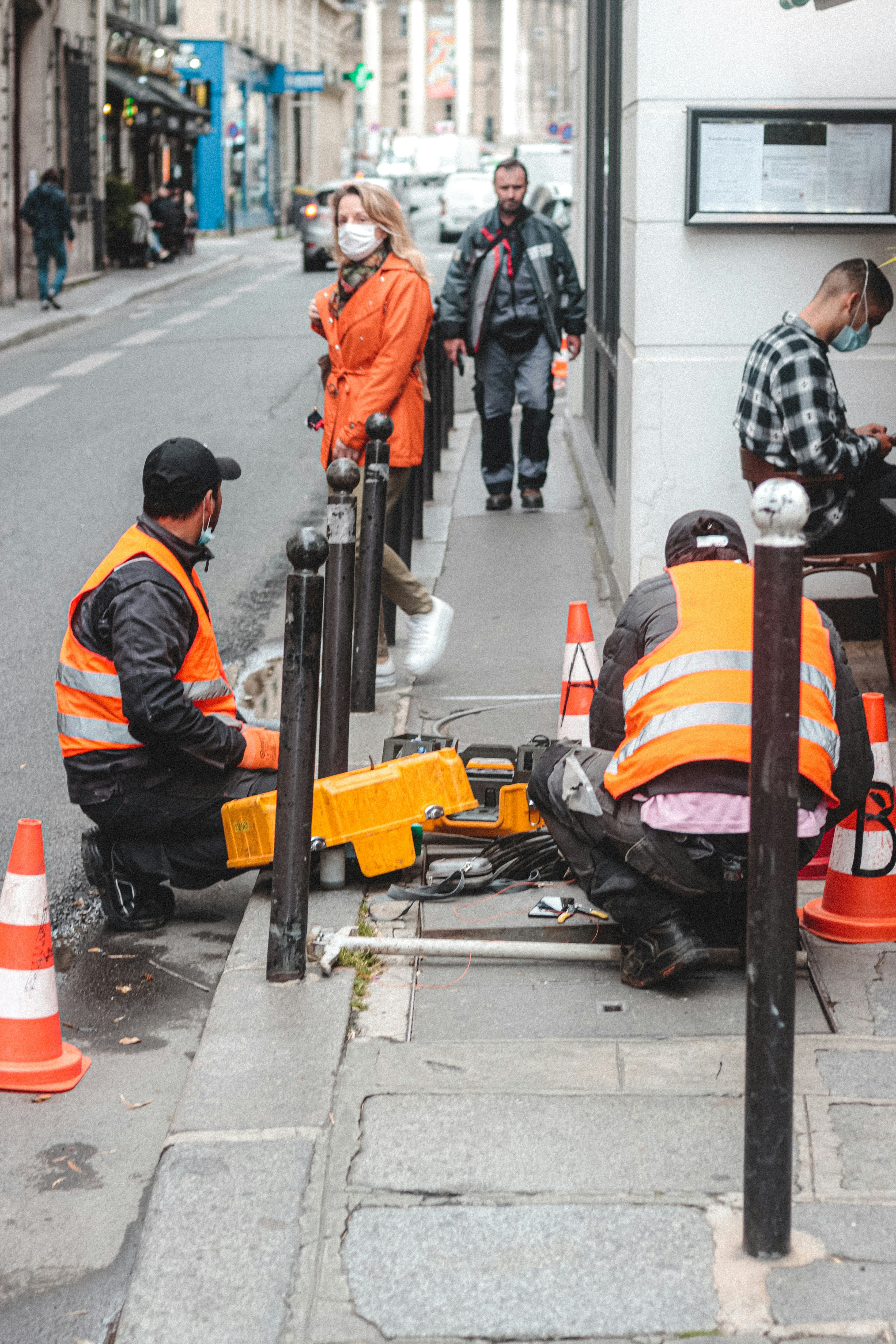 man in orange and black jacket and black helmet riding on black motorcycle during daytime